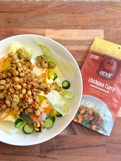 Anar Gourmet Foods all natural, gluten-free chickpea curry seasoning packet beside a bowl of chickpea curry salad with lettuce, cucumber, and carrots