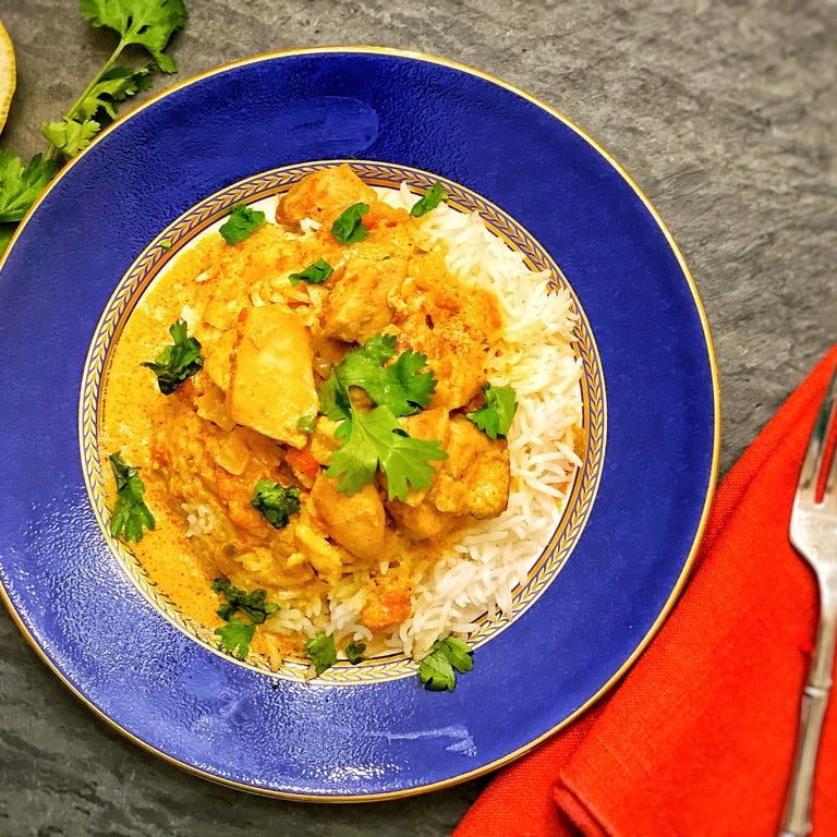 Anar Gourmet Foods, all natural, gluten-free, grandma's spicy chicken curry seasoning and recipe, chicken curry over basmati rice on a blue and gold plate