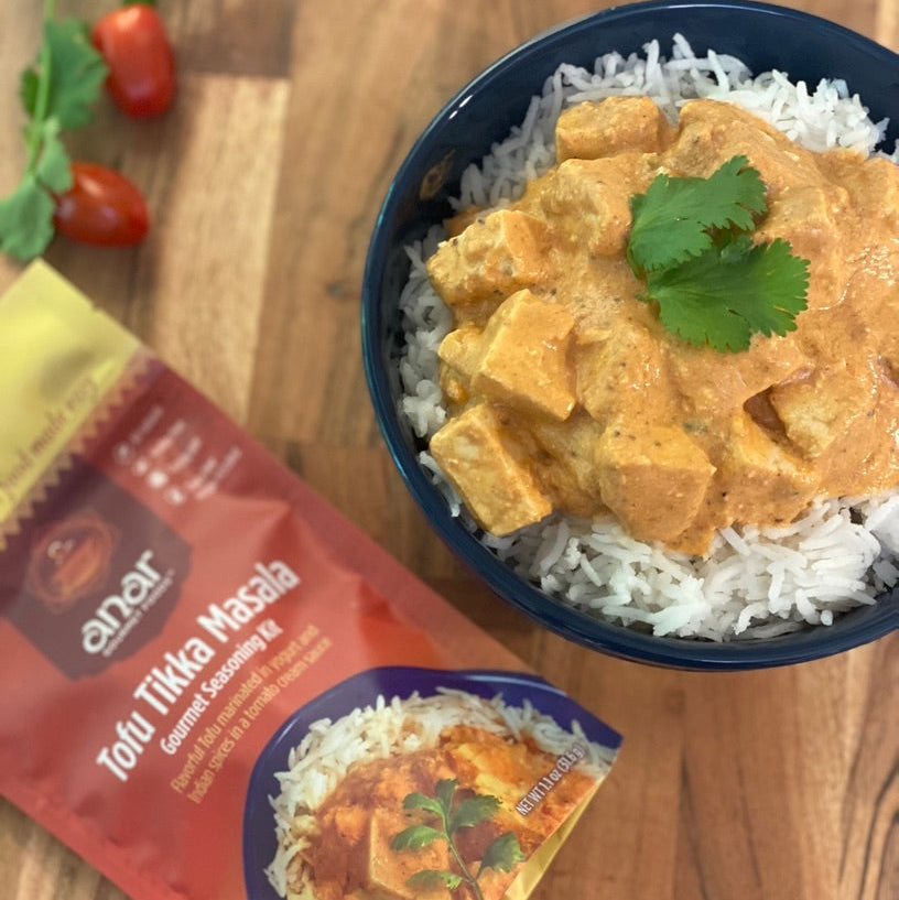 Anar Gourmet Foods all-natural, gluten-free tofu tikka masala seasoning — tofu curry over rice with seasoning packet, tomatoes, and cilantro