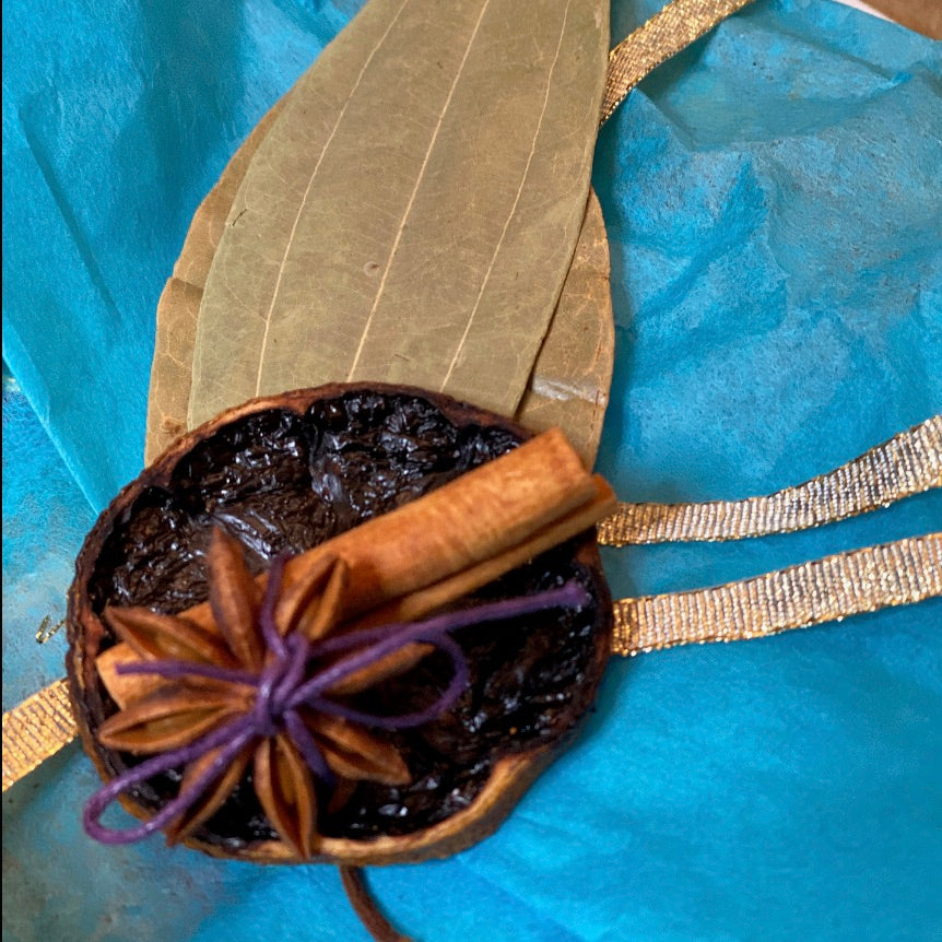 Anar Gourmet Foods vegetarian lovers seasoning blends gift box — close-up of dehydrated orange, star anise, cinnamon stick, and bay leaf decoration on teal tissue