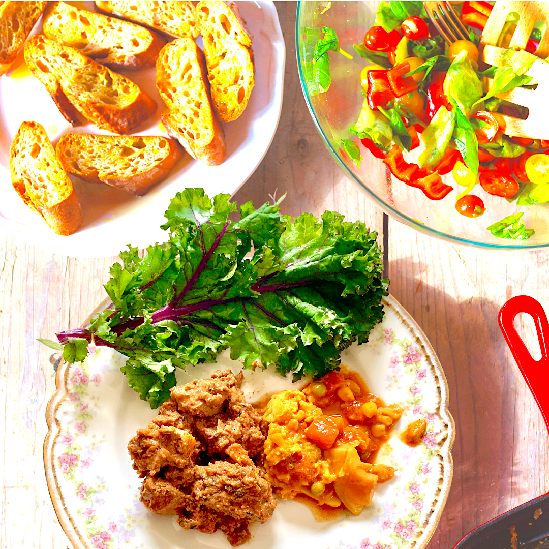 Butter Chicken plated with kale, tomato salad, and toasted bread, made by a customer using Anar Gourmet Foods all natural, gluten-free seasoning
