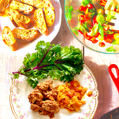 Butter Chicken plated with kale, tomato salad, and toasted bread, made by a customer using Anar Gourmet Foods all natural, gluten-free seasoning