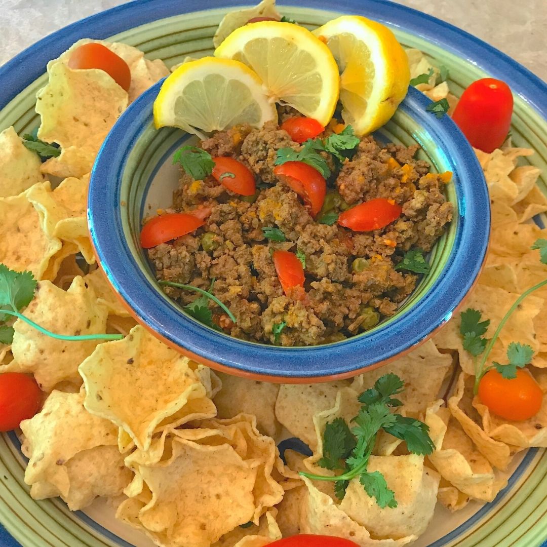 Ground Beef Keema Curry with corn chips, tomatoes, and lemon, made with Anar Gourmet Foods all natural, gluten-free seasoning