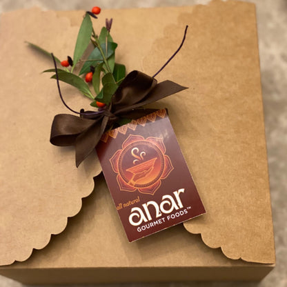 Anar Gourmet Foods Indian seasoning blends gift box — closed kraft box with brown ribbon, greenery, and branded tag