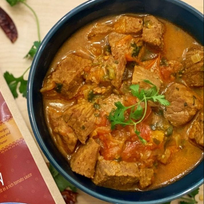 Anar Gourmet Foods all-natural, gluten-free spicy beef curry, plated in a bowl with cilantro garnish and seasoning package