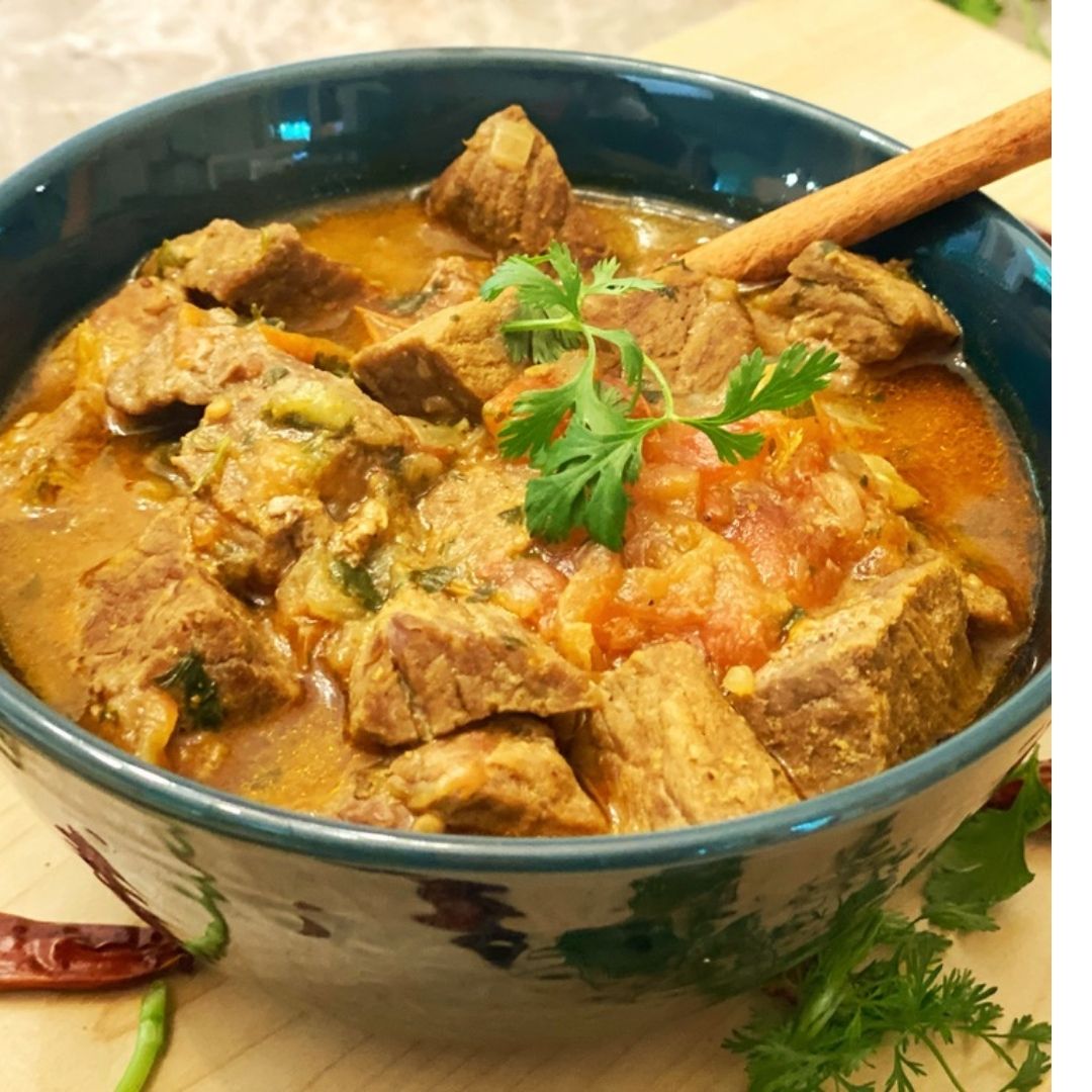 Anar Gourmet Foods all-natural, gluten-free spicy beef curry, plated with fresh cilantro and a cinnamon stick